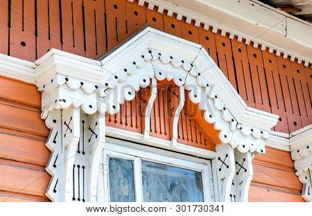 Russian Traditional Wooden Architecture. Facade Of An Old House Decorated With Wooden Carvings, Plat
