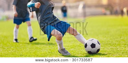 Young Football Soccer Player Kick Ball On Green Grass Sports Venue. Soccer Kick Moment. Youth Footba