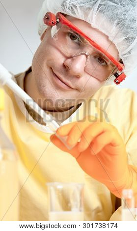 Young Microbiologist In Protective Workwear Smiles Into Camera
