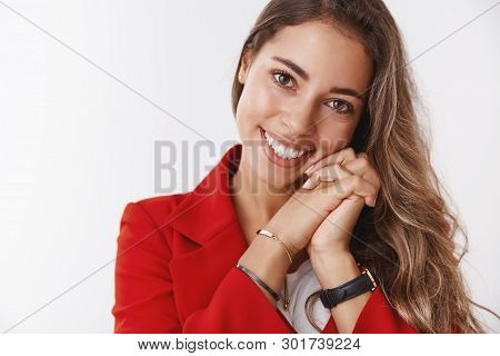 Charming Romantic Curly-haired Modern Woman Wearing Red Jacket Leaning Head Pressed Hands Smiling Te