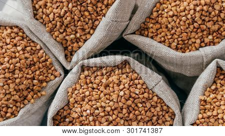 Food And Healthy Eating Concept. Close Up Shot Of Raw Buckwheat In Sacks. Nurture. Dry Healthy Cerea