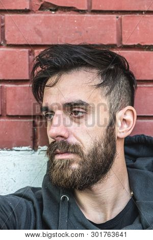 Homeless Man, Homeless Man Drug And Alcohol Addict Sitting Alone And Depressed On The Street Leaning