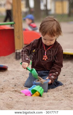 Klein meisje spelen op zand-Box