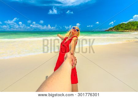 Tropical Summer Holidays. Follow Me. Tourist Woman In Red Dress Holding Hand Of Her Partner At Seych