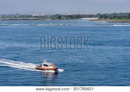 Bali, Indonesia - February 25, 2019: Outside Benoa Port. The Arrival Of Orange Pilot Boat Drawing A 