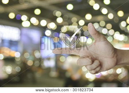 Security Shield With Check Mark Icon On Finger Over Blur Light And Shadow Of Shopping Mall, Technolo