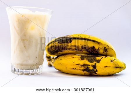Raw Organic Fresh Banana And Its Smoothie Or Shake Or Banana Milk In A Glass Isolated On White.