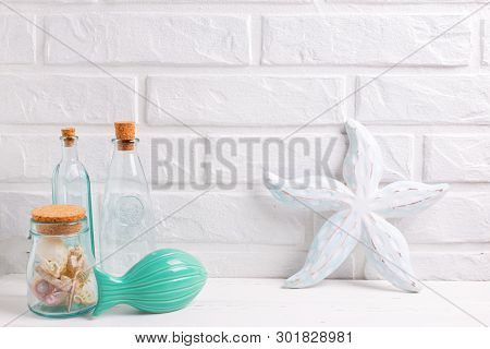 Nautical Or Marine Decorations Near By White Brick Wall. Decorative Sea Star, Turquoise Fish,  Blue 