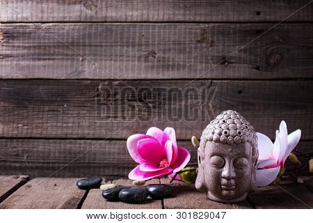 Spa Setting.  Buddha, Stones And Pink Magnolia Flowers On Rustic Wooden Textured Background. Spa Or 