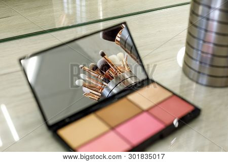 Makeup Brushes Are Reflected In A Palette Mirror With Shadows