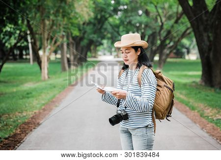 Asian Woman Backpack Traveler Use Map When Traveling At Rain Forest.holiday Vacation Concept.journey