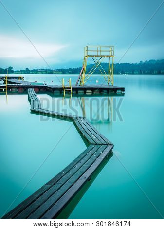 Foggy Morning At The Lake In Walchsee With Jetty And Diving Tower
