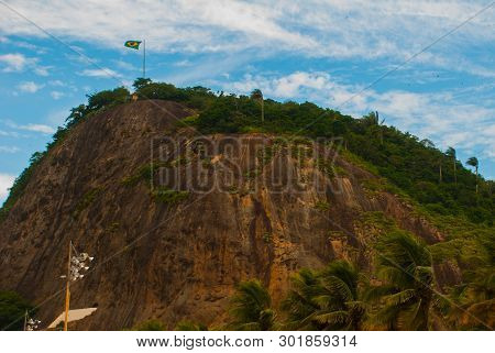 Rio De Janeiro, Lama Beach, Brazil: Beautiful Landscape With Mountain And Beach. Flag Of Brazil On T