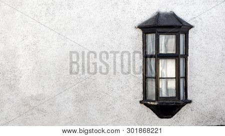 Exterior View Of A Beautiful Old English Stone Cottage With Window.