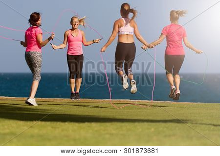 Group Of Young People Doing Their Fitness Training By The Sea, Using Skipping Rope