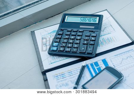 Calculator, Smartphone And Financial Documents On The Businessm