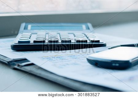 Calculator, Smartphone And Financial Documents On The Businessm