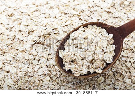 Raw Oatmeal With A Spoon On The Table. Traditional Carbohydrate Breakfast