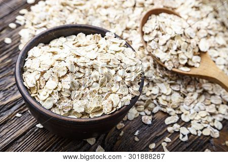 Raw Oatmeal With A Spoon On The Table. Traditional Carbohydrate Breakfast