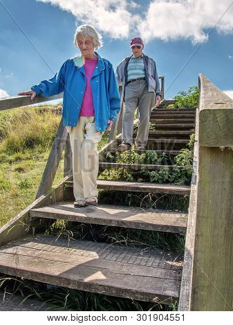 Elderly Couple In The British Countryside At Danebury Ring.