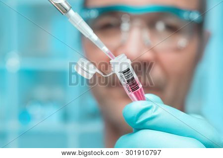 Scientist Or Tech Holds Liquid Biological Sample In Gloved Hands