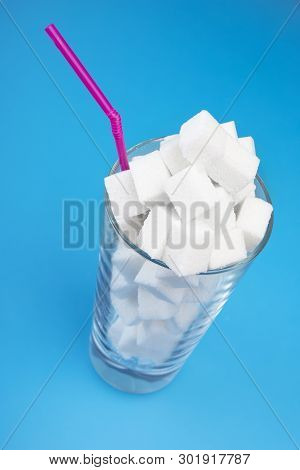 Concept Of Excessive Sugar Consumption Is Harmful To Health. Sugar Cubes On The Glass.