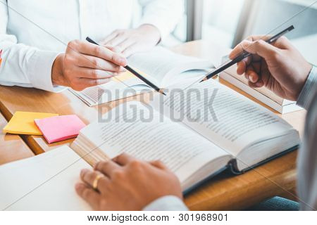 High School Or College Students Studying And Reading Together In Library