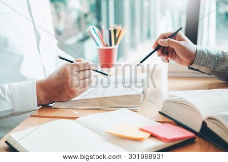 High School Or College Students Studying And Reading Together In Library