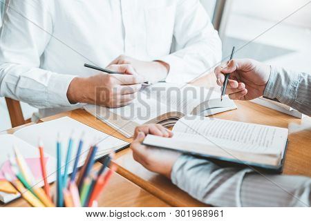 High School Or College Students Studying And Reading Together In Library