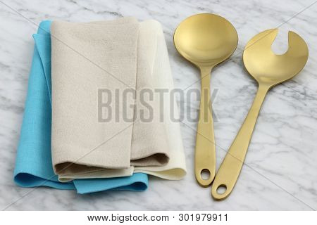 Trendy And Beautiful Golden Serving Spoon And Fork Set Styled With Hemstitch Linen Napkin