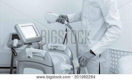 Male Beautician Using Modern Machine For Vitiligo Treatment Black White Image With A Blue Toning