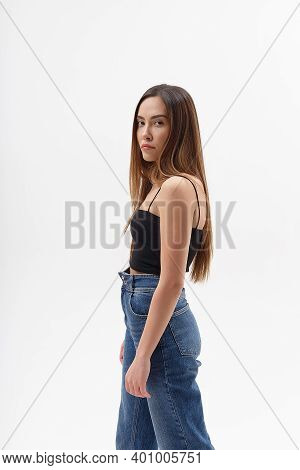 Portrait Of Young Attractive Asian Woman With Long Hair In Black Top, Blue Jeans Isolated On White S