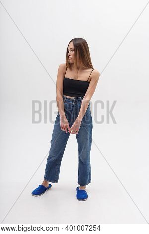 Young Attractive Asian Woman With Long Hair In Black Top, Blue Jeans Isolated On White Studio Backgr
