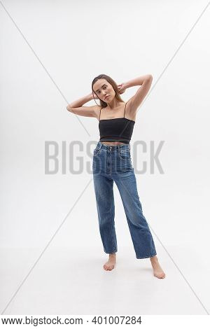 Young Attractive Asian Woman With Long Hair In Black Top, Blue Jeans Isolated On White Studio Backgr