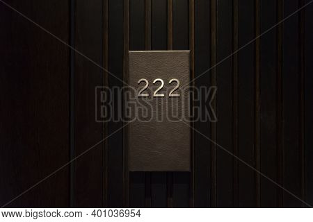 Hotel Room With 222 Number, Dark Wood Door, Black Number Plate With Golder Numbers
