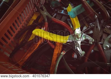 Old Pliers In Plastic Basket. Second-hand Tool For Sale At Tools Market. Old Pliers In Tool Tray. To