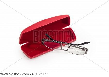 Modern Eyeglasses In Metal Gray Rim With Folded Temples Against The Red Hard Spectacle-case On A Whi