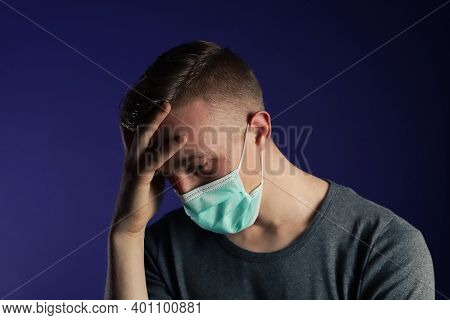 Caucasian Man In A Medical Gause Mask With Palm On Nis Head.