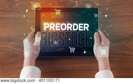 Close-up of a hand holding tablet with PREORDER inscription, online shopping concept