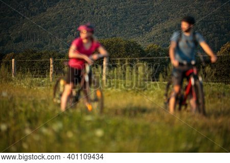 Happy couple riding bicycles outside, healthy lifestyle fun concept, taking a break admiring the view