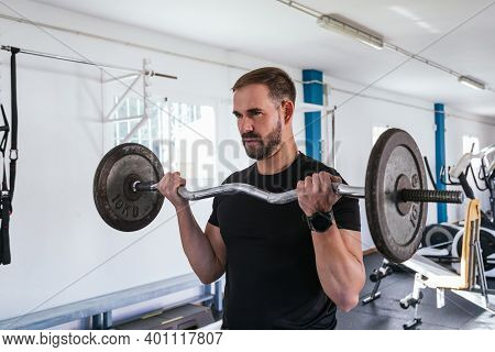 Young Man Doing Biceps Curl With Bar. Bar Exercise. Concept Of Health And Wellbeing