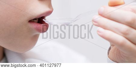 A Spoonful Of Syrup Is Brought To The Child's Mouth