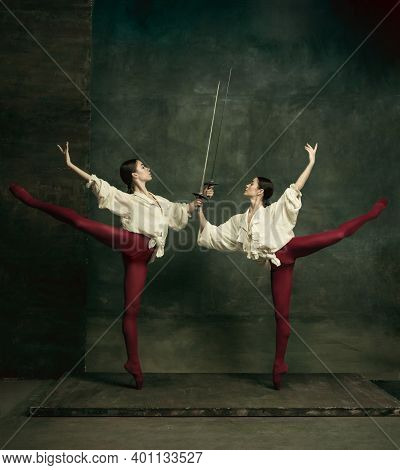 Fight. Two Young Female Ballet Dancers Like Duelists With Swords On Dark Green Background. Caucasian