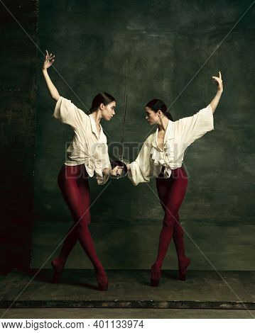 Emotions. Two Young Female Ballet Dancers Like Duelists With Swords On Dark Green Background. Caucas