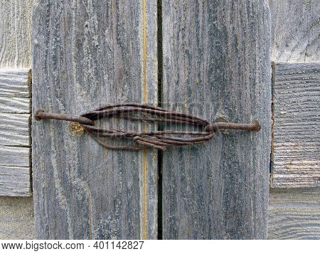 Close Up Of Rusty Wire Lock On Old Gray Wood. Fwi. Construction And Masonry Concept.