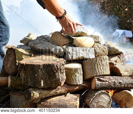 Hands Leaving Stones Called Grandmothers On The Firewood For The Temazcal.