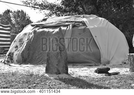 Inipi Or Sweat Lodge Covered By Blankets And Stone Driven Into The Ground At Its Entrance. Black And