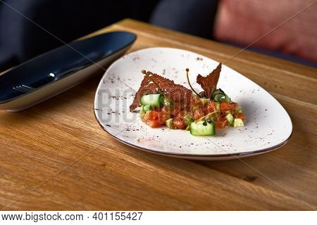 Salad With Smoked Salmon And Cucumber On Wooden Table. Serving In A Restaurant, Menu.