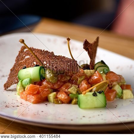 Salad With Smoked Salmon And Cucumber On Wooden Table. Serving In A Restaurant, Menu.