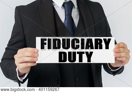 Business And Finance Concept. A Businessman Holds A Sign In His Hands Which Says Fiduciary Duty